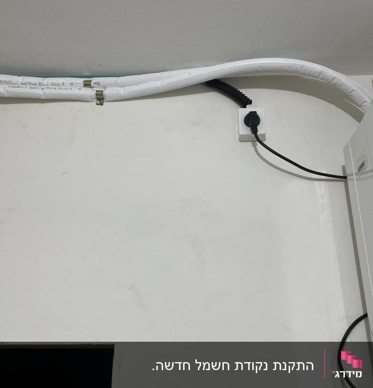 כבל חשמל מחובר לשקע בקיר